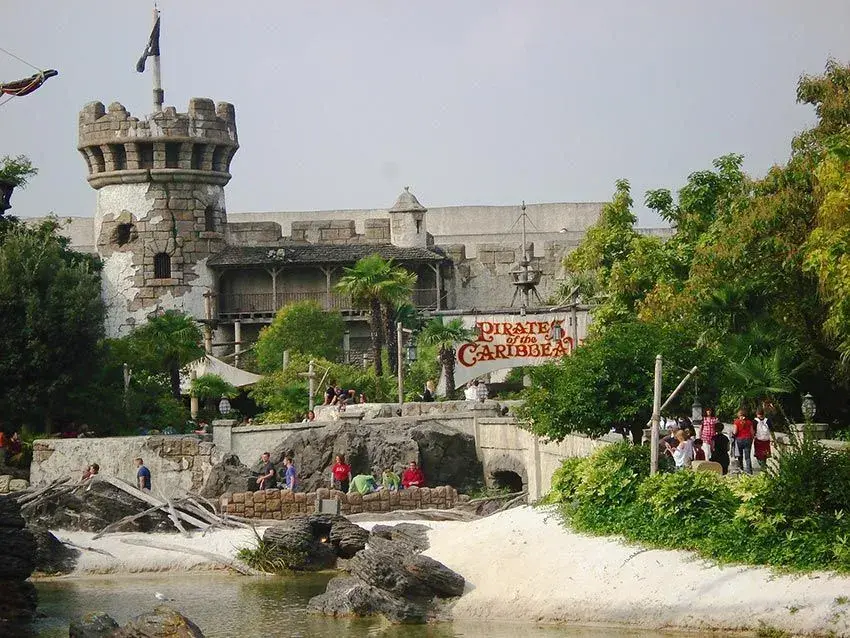 Vista exterior de la atracción Piratas del Caribe con multitud de visitantes listos para entrar - Aventura pirata en Disneyland
